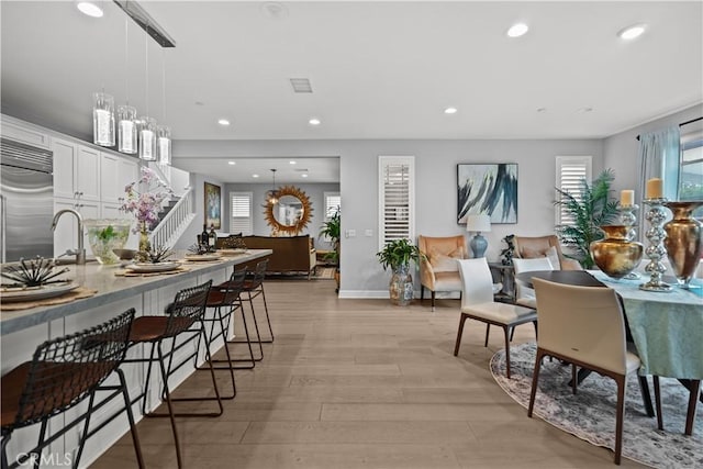 dining area with recessed lighting, light wood finished floors, baseboards, and a healthy amount of sunlight