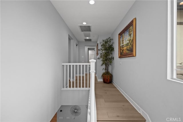 hall with visible vents, recessed lighting, baseboards, and wood finished floors