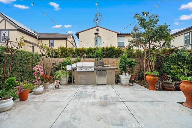 view of patio with an outdoor kitchen, a fenced backyard, and a grill