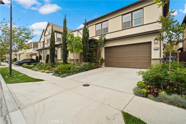 view of front facade featuring an attached garage, concrete driveway, and stucco siding