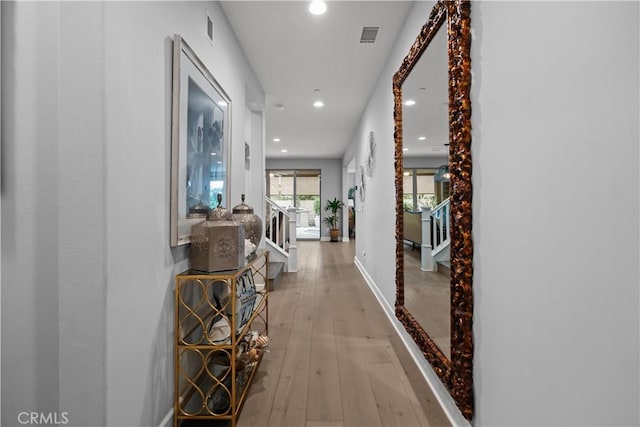 hall with baseboards, light wood finished floors, recessed lighting, and visible vents