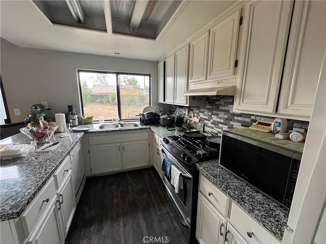 kitchen featuring white dishwasher, under cabinet range hood, a sink, gas range, and dark wood-style floors