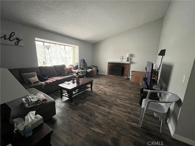 living area with a fireplace, a textured ceiling, baseboards, and wood finished floors