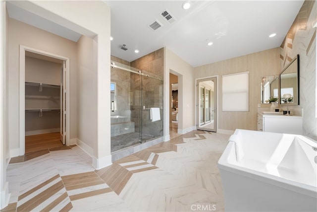 bathroom featuring a freestanding tub, vanity, visible vents, a stall shower, and baseboards