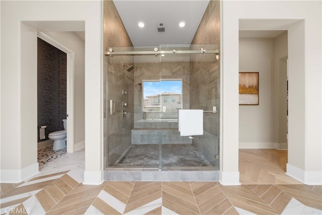 bathroom with toilet, baseboards, a shower stall, and recessed lighting