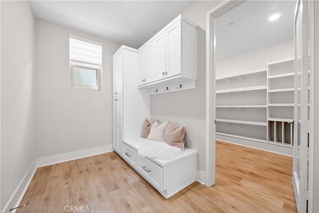 mudroom with light wood finished floors and baseboards