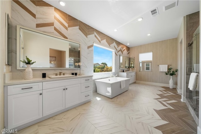 full bath featuring a sink, visible vents, two vanities, and a stall shower