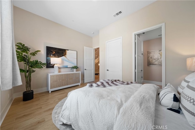 bedroom featuring visible vents, light wood-type flooring, and baseboards
