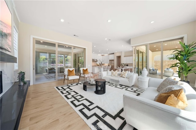 living room featuring recessed lighting, visible vents, and light wood-style flooring