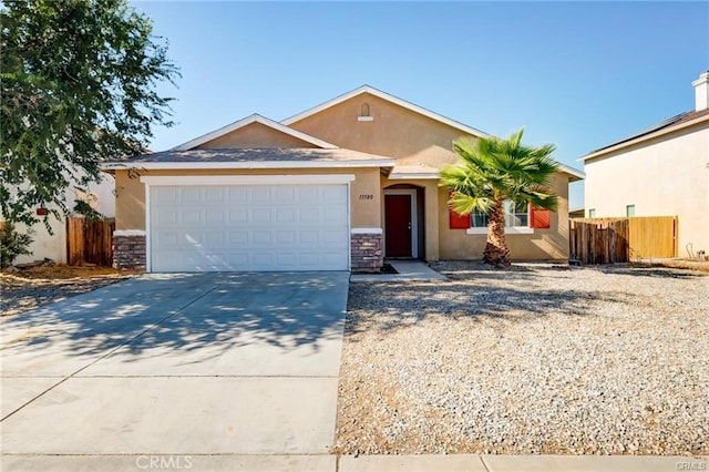 single story home featuring concrete driveway, stucco siding, stone siding, and fence
