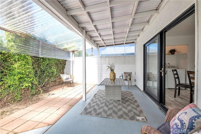 view of patio with washing machine and dryer and fence