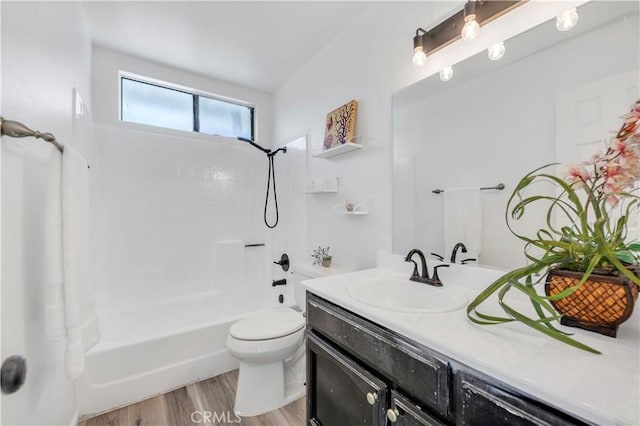 bathroom featuring vanity, wood finished floors, toilet, and shower / washtub combination