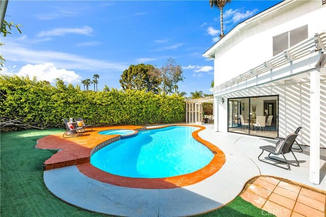 view of pool with a patio, fence, a pergola, and a pool with connected hot tub