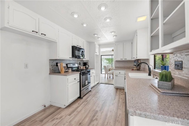 450 Anchor Way, Carlsbad, CA 92008 - kitchen with stainless steel range with gas stovetop, black microwave, a sink, tasteful backsplash, and white cabinetry