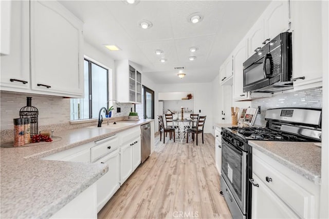 kitchen featuring a sink, white cabinets, light wood-style floors, and stainless steel appliances