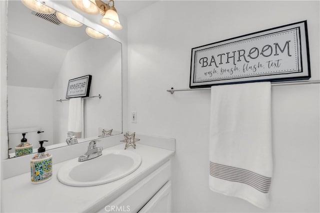 bathroom with visible vents, lofted ceiling, and vanity