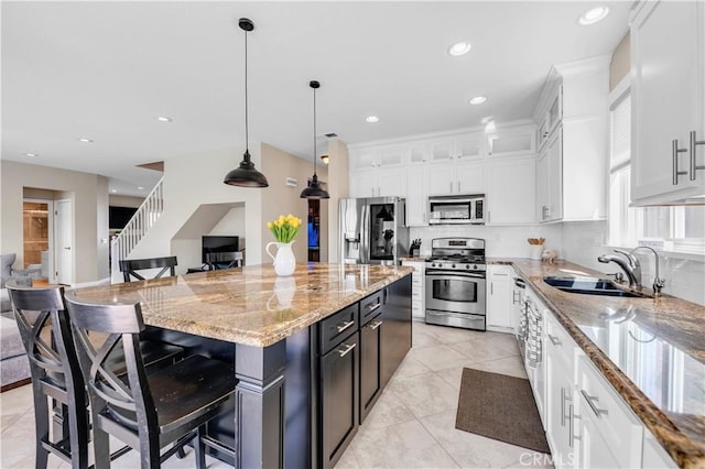 43273 Modena Dr, Temecula, CA 92592 - kitchen with a kitchen breakfast bar, white cabinets, appliances with stainless steel finishes, light stone counters, and a sink
