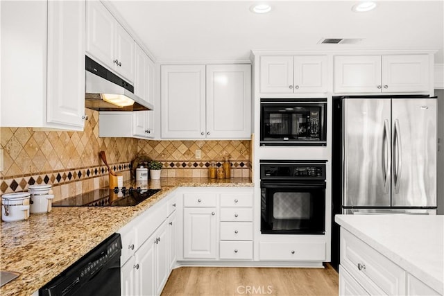 19 Alameda, Irvine, CA 92620 - kitchen featuring under cabinet range hood, visible vents, black appliances, tasteful backsplash, and white cabinetry