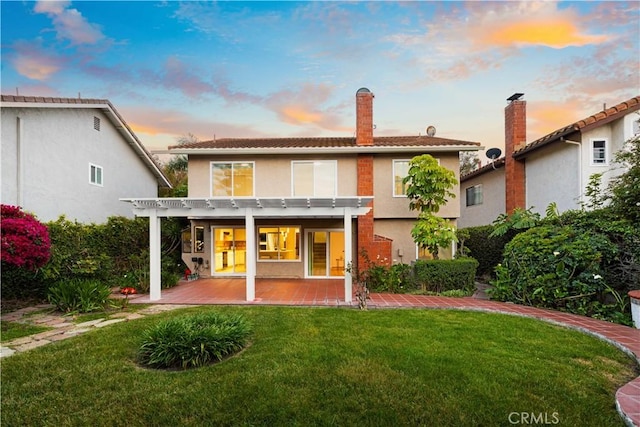 19 Alameda, Irvine, CA 92620 - back of property featuring a lawn, a patio, a pergola, and stucco siding