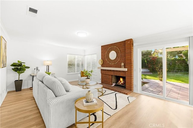 19 Alameda, Irvine, CA 92620 - living room with a fireplace, light wood-type flooring, a healthy amount of sunlight, and visible vents
