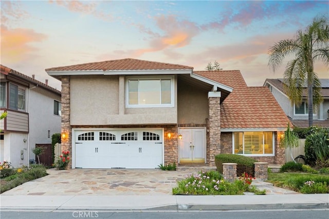 19 Alameda, Irvine, CA 92620 - view of front of property featuring stucco siding, a tile roof, driveway, stone siding, and a garage