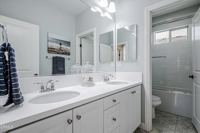 bathroom featuring toilet, double vanity, a sink, and tub / shower combination