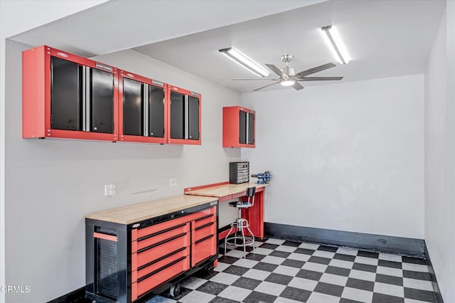 office area featuring ceiling fan, dark floors, and baseboards