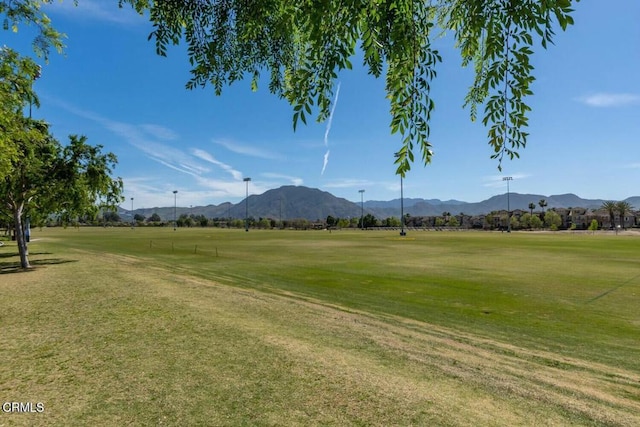 view of community with view of golf course, a yard, and a mountain view