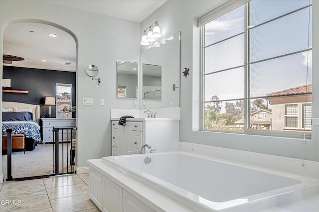 ensuite bathroom featuring a bath, vanity, ensuite bath, recessed lighting, and baseboards