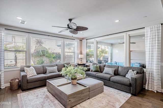 living room featuring a ceiling fan, visible vents, and plenty of natural light