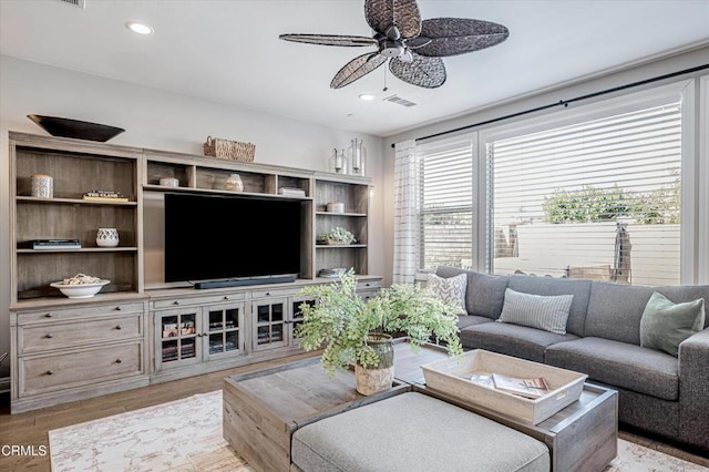 living room with recessed lighting, visible vents, light wood-type flooring, and a ceiling fan