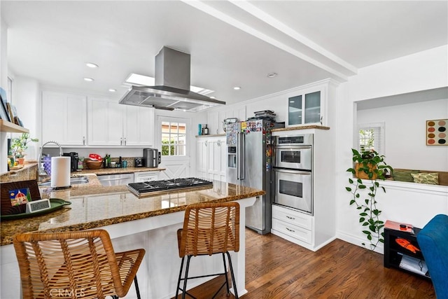 2818 Francis Ln, Costa Mesa, CA 92626 - kitchen with dark wood-style flooring, island range hood, appliances with stainless steel finishes, light stone countertops, and a peninsula