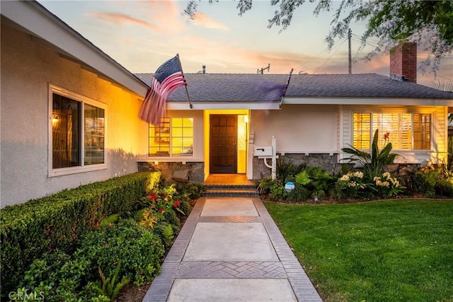 2818 Francis Ln, Costa Mesa, CA 92626 - property entrance with a lawn, a chimney, stone siding, and stucco siding