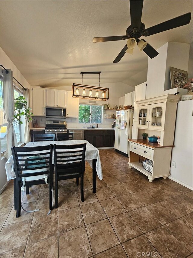 29129 Crestline Dr, Menifee, CA 92584 - kitchen featuring stainless steel appliances, a sink, lofted ceiling, white cabinetry, and a ceiling fan