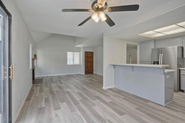 321 N Melrose Dr Unit A, Vista, CA 92083 - kitchen featuring ceiling fan, light wood-style flooring, a peninsula, a kitchen bar, and light countertops