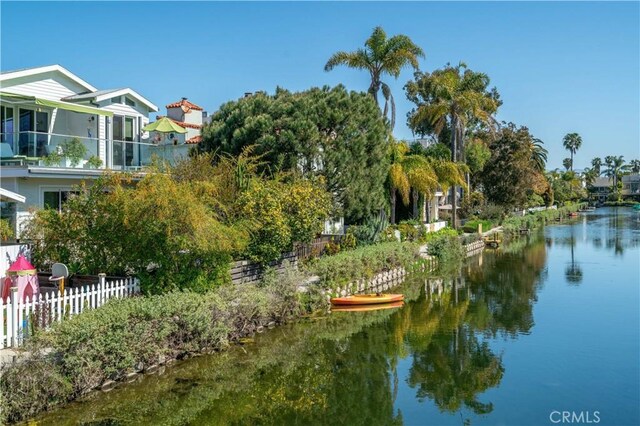 exterior space with a water view and fence