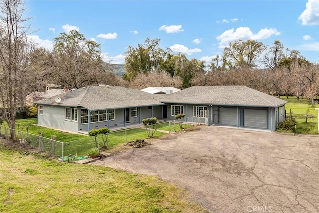 single story home featuring aphalt driveway, a garage, and a front lawn