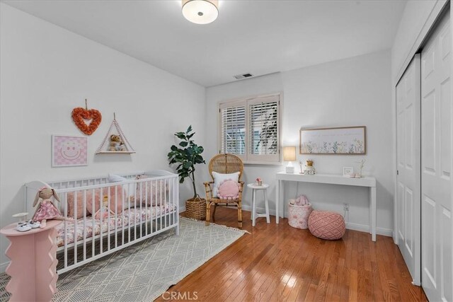 2824 Westwood Blvd, Los Angeles, CA 90064 - bedroom with baseboards, a closet, a crib, visible vents, and hardwood / wood-style floors