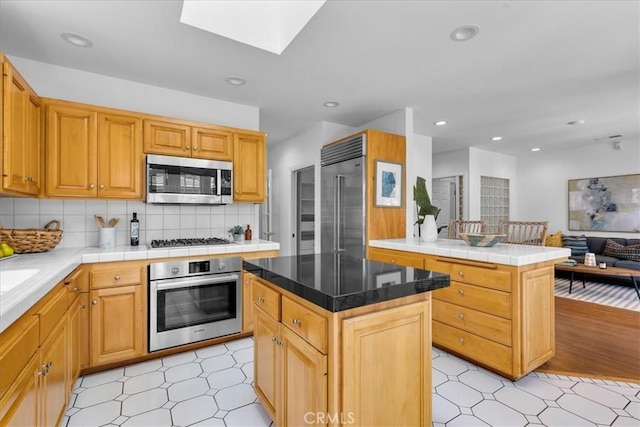 2824 Westwood Blvd, Los Angeles, CA 90064 - kitchen with light floors, a kitchen island, a skylight, stainless steel appliances, and open floor plan