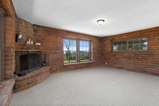 2483 Buckman Springs Rd, Campo, CA 91906 - unfurnished living room featuring carpet flooring, a textured ceiling, brick wall, and a fireplace
