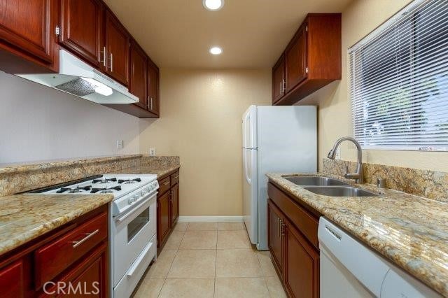 kitchen featuring light tile patterned floors, a sink, white appliances, recessed lighting, and light stone counters