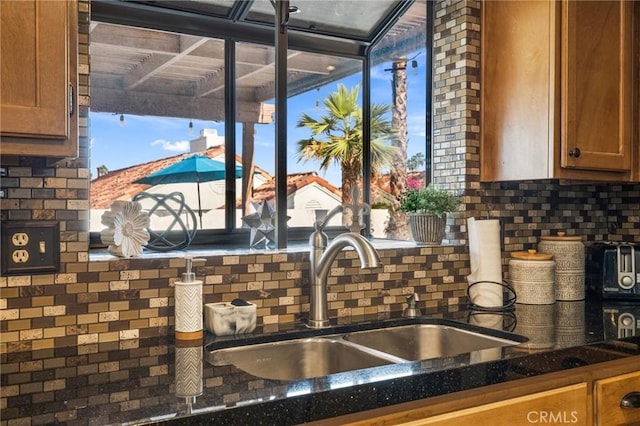 43590 Warner Trl, Palm Desert, CA 92211 - kitchen with a sink, backsplash, brown cabinets, and dark countertops