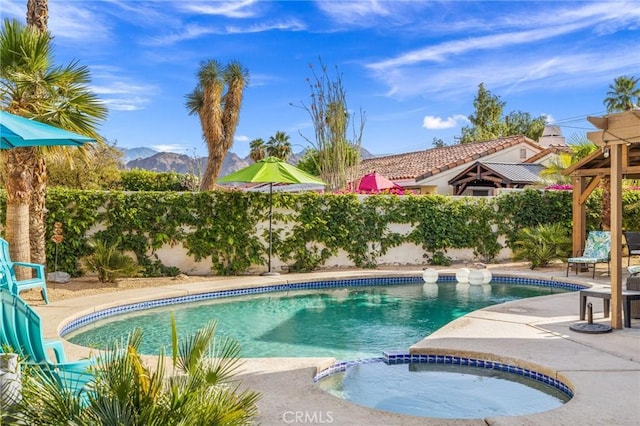 43590 Warner Trl, Palm Desert, CA 92211 - view of pool featuring a fenced backyard, a patio area, a mountain view, and a pool with connected hot tub
