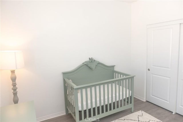 15188 Horizon St Unit 8, Fontana, CA 92336 - bedroom with a crib, baseboards, and wood finished floors