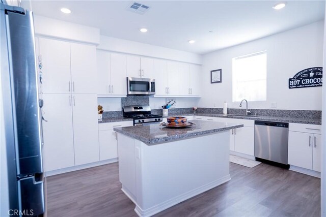 15188 Horizon St Unit 8, Fontana, CA 92336 - kitchen with visible vents, white cabinets, wood finished floors, stainless steel appliances, and a kitchen island