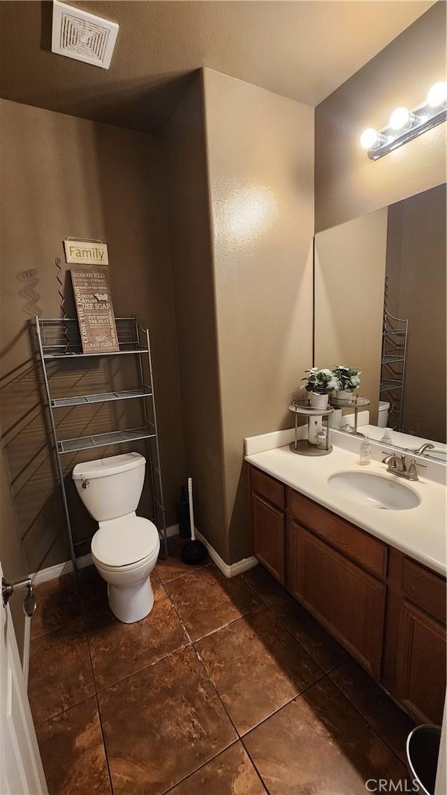 12613 Torrey Pine Rd, Moreno Valley, CA 92555 - half bathroom with toilet, vanity, tile patterned flooring, and baseboards