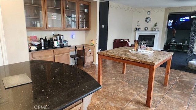 12613 Torrey Pine Rd, Moreno Valley, CA 92555 - kitchen featuring a fireplace, glass insert cabinets, dark stone countertops, and open floor plan