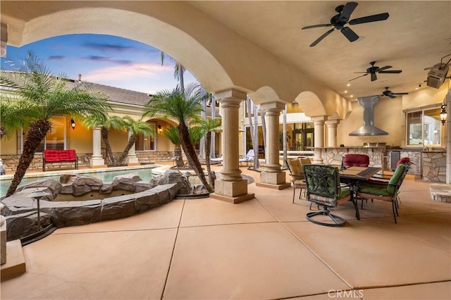 view of patio with outdoor dining space, an outdoor kitchen, and a ceiling fan