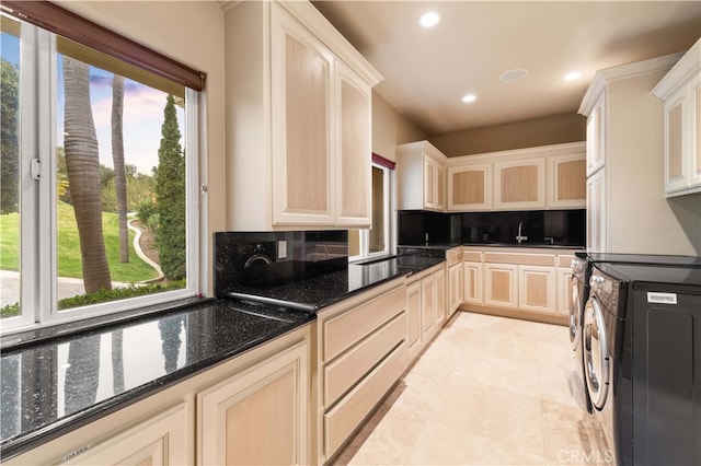 kitchen with dark stone countertops, recessed lighting, glass insert cabinets, decorative backsplash, and a sink