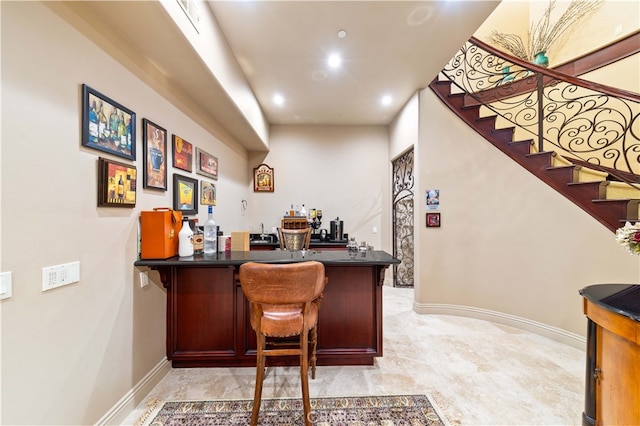 bar with a bar, baseboards, recessed lighting, and stairs